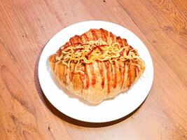 Close up picture of Chinese New Year Croissant Series topped with noodles. photo