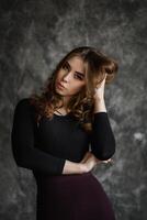 Expressive portrait of a young woman striking a confident pose in an artistic studio setting photo