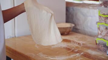 Male hands prepares dough for pizza. Baker making pizza dough on wooden table before baking. Cook forming the dough with his hands on a round deco. Close-up. video
