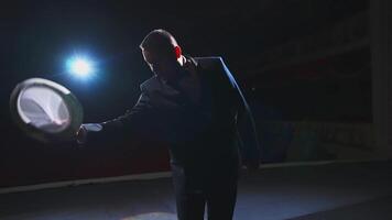 Male actor performing in the theater. Funny man putting on white hat and began dancing on stage in dark light. View from the stage. video
