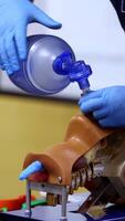Training course on dummy head. Practitioner in medical gloves performing a resuscitation procedure on a manikin. Practical skills. Vertical video