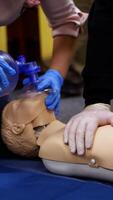Training practice on a dummy. Students study doing resuscitation technique on a mannequin to save life. Cardiopulmonary resuscitation. Vertical video