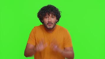 Young indian man appearing from below and waves hand palm in hello welcome gesture welcomes someone video