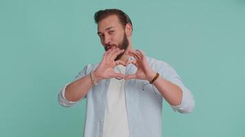 Smiling arabian man makes heart gesture demonstrates love sign expresses good feelings and sympathy video