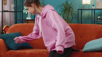 Tired Caucasian preteen school girl enters room lying down on couch taking a rest, falling asleep video