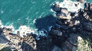 Aerial view Top down seashore. Waves crashing on rock cliff video