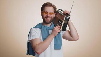 Happy man using retro tape record player to listen music disco dancing of favorite track having fun video