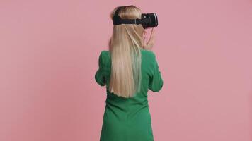 Woman using virtual reality headset helmet app to play realistic simulation 3D games, watching video