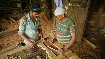 Two artisans standing operating in timber workshop video