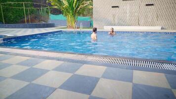 Lovers are playfully swimming at resort pool video