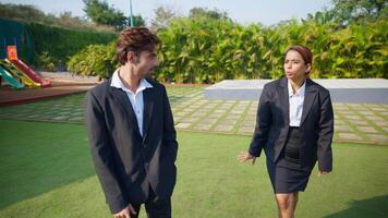 Businesspeople stand in a park discussing plot video