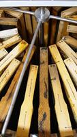 Honey frames are stacked closely to each other in a metal barrel. The centrifuge device being rotated to extract honey. Vertical video