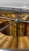 Rotating mechanism working inside the metal barrel. Electric centrifuge machine extracting honey from frames. Close up. Vertical video
