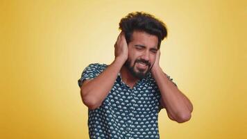 Annoyed irritated handsome man covering ears gesturing No avoiding advice ignoring noise loud voices video