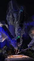 Da Vinci surgical robot coated with plastic in the middle of dark surgery room. Robotic arms write a letter on the operational table. Christmas decorations and lights at backdrop. Vertical video