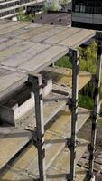 Unfinished building of abandoned factory. Old industrial architecture in spring. Camera rising. Aerial view. Vertical video