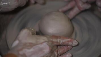A clay ball is spun on a potter's wheel to make a piece video