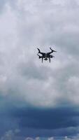 Flying drone over fields. Drone capturing aerial shots using camera against a blue sky Vertical video