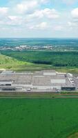 Large factory in nature. Panoramic view on industrial complex in the countryside. Industrial territory on green field. View from the air. Vertical video