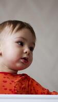 Active cute toddler jumping standing in his cot. Caucasian toddler looking down and laughing sweetly. Low angle view. Vertical video