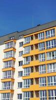 View from the drone of the contemporary residential building in the city. Exterior of a modern design of multistory apartment building. Aerial view. Vertical video
