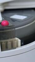 Few test tubes are moving in the apparatus. Close up. Advanced equipment in the technological science laboratory for medical tests. Vertical video