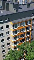 modern Wohn Komplex im das Stadt. Bewegung Kamera Aussicht von das neu gebaut Wohnung Gebäude im sonnig Tageszeit. Außen von Neu städtisch Infrastruktur Konzept Vertikale video