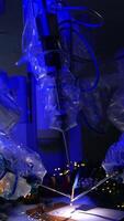 Da Vinci robot holding and using writing appliances. Robotic arms covered in plastic rotate the old-fashioned writing pen. Dark room backdrop. Vertical video