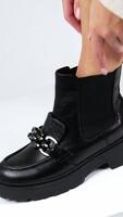 Frau stellen einer Fuß auf das Weiß Würfel zu zeigen stilvoll Stiefel. Dame berühren das Schuh mit Silber dekorativ Kette. schließen hoch. Vertikale video