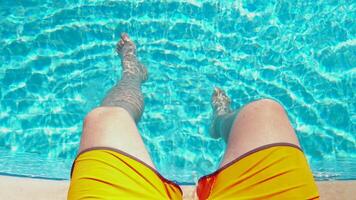 Swinging your legs in a blue pool on a sunny day video