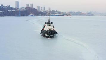 View of a tug making its way through the ice at sunset video