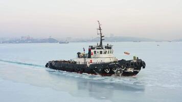 Top view of a tug making its way through the ice at sunset video