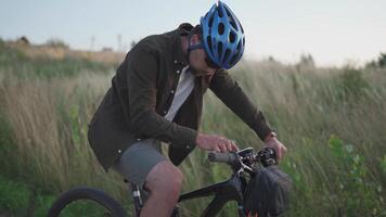 People, sports, active lifestyle concept. Cyclist using navigator device examines map and looks for GPS coordinates on screen of gadget while cycling outdoors. Activity tracker on handlebars of cycle. video