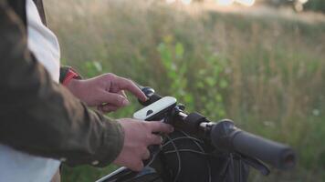 People, sports, active lifestyle concept. Cyclist using navigator device examines map and looks for GPS coordinates on screen of gadget while cycling outdoors. Activity tracker on handlebars of cycle. video