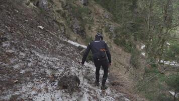 Man cyclist pulls bicycle through avalanche in mountains. Bicyclist is trapped in obstacle and is pulling his cycle through an ice slide with bicycle in his hands. Avalanche on cycling route in Alps. video