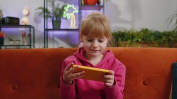 Worried funny child kid girl playing online racing simulator or shooter games on smartphone video