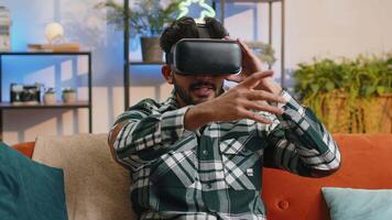 Man using virtual reality futuristic technology headset to play simulation 3D game at home video