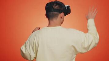 Handsome man using virtual reality headset helmet to play simulation game app watching content video
