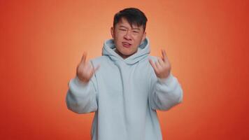 Asian man showing rock n roll dance gesture by hands, cool sign, shouting yeah with crazy expression video