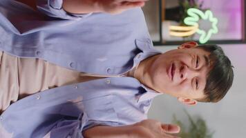 Asian man smiling friendly at camera, waving hands gesturing hello, hi, greeting at home on sofa video
