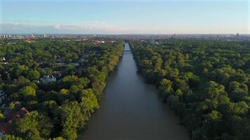 Aerial view of the Isar River in Munich, Germany, during summer. The English Garden offers lush green spaces, peaceful nature, flowing water, and scenic landscapes, creating a serene urban escape. video
