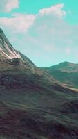 hillside overgrown with dry grass against the backdrop of snow-capped mountains video