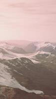 large snow patch left over on the volcanic rock field of a mountain in summer video