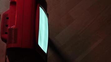 Old red television showing static noise on wooden background video