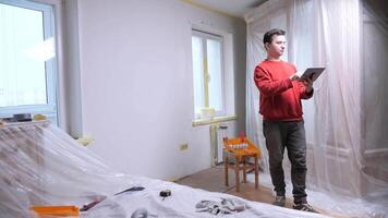 man using tablet during apartment renovation project. renovation project in an apartment on a tablet video