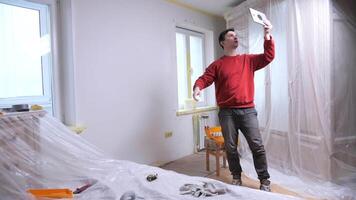 blogger Handyman planning renovation project using tablet in empty room. Man call. Diy video
