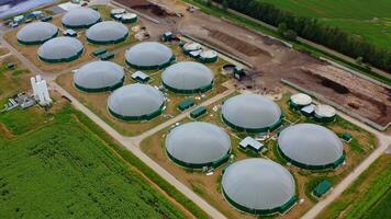 Exterior of biogas complex. Biogas is produced by fermenting biomass. Storage tanks for organic gas on the field. View from the air. video