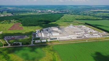 Modern factory surrounded by nature. Large area of industrial complex among green fields. Manufacturing in natural environment. Aerial view. video