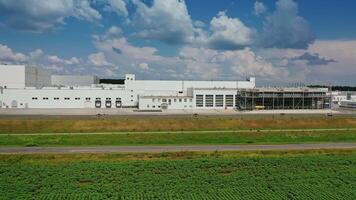 Industrial plant on green field. Huge territory with white buildings against blue sky. Exterior of factory in nature. Aerial view. video