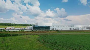 Industrial area among natural environment. Huge territory of manufacturing complex on green field under beautiful summer sky. Front view. video